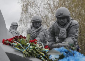 Λουλούδια με κορδέλες στα χρώματα της Ουκρανίας έχουν τοποθετηθεί στο μνημείο των «υγροποιητών», οι οποίοι πέθαναν, μολυσμένοι από ραδιενέργεια, στην προσπάθειά τους να καθαρίσουν τα πυρηνικά απόβλητα του ατυχήματος στο Τσερνόμπιλ (φωτ.: EPA/Sergey Dolzhenko)