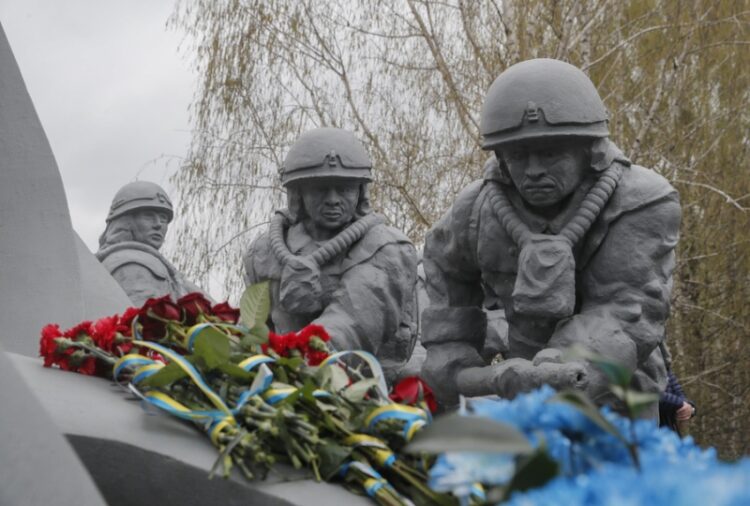 Λουλούδια με κορδέλες στα χρώματα της Ουκρανίας έχουν τοποθετηθεί στο μνημείο των «υγροποιητών», οι οποίοι πέθαναν, μολυσμένοι από ραδιενέργεια, στην προσπάθειά τους να καθαρίσουν τα πυρηνικά απόβλητα του ατυχήματος στο Τσερνόμπιλ (φωτ.: EPA/Sergey Dolzhenko)