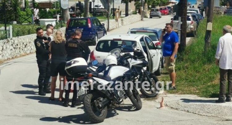 Αστυνομικός διακρίνεται να έχει στην αγκαλιά του το ενός έτους παιδί, το οποίο είχε μείνει μόνο του στο αυτοκίνητο για τουλάχιστον μισή ώρα (φωτ.: Imerazante.gr)