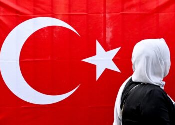Γυναίκα στην Τουρκία στέκεται μπροστά από τη σημαία της χώρας (φωτ.: . EPA/Filip Singer)