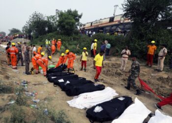 Σοροί θυμάτων της σιδηροδρομικής τραγωδίας κείτονται στο έδαφος κατά τη διάρκεια επιχειρήσεων των σωστικών συνεργείων στο σημείο (φωτ.: EPA/Piyal Adhikary)