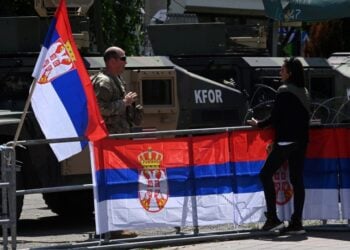 Σερβίδα συνομιλεί με Αμερικανό στρατιώτη, μέλος της δύναμης του ΝΑΤΟ, μπροστά από δημοτικό κτήριο στο Λεπόσαβιτς, στο Κόσοβο (φωτ.: EPA/Georgi Licovski)