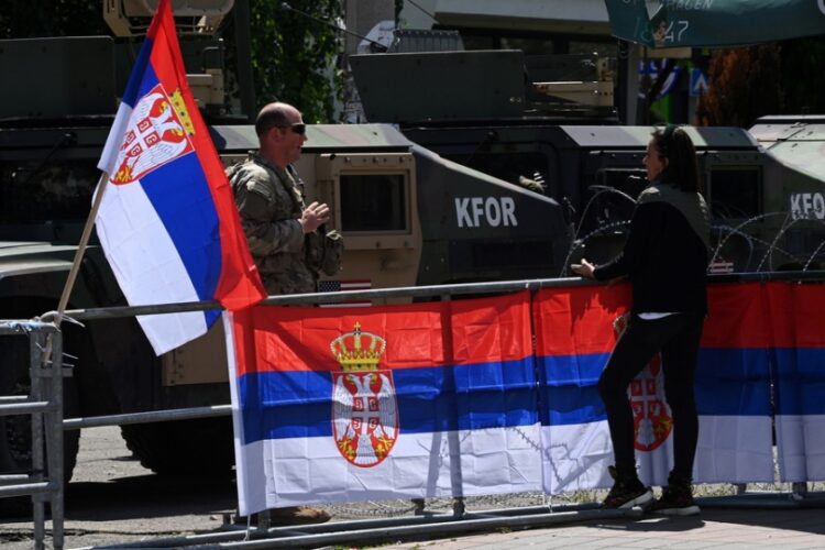 Σερβίδα συνομιλεί με Αμερικανό στρατιώτη, μέλος της δύναμης του ΝΑΤΟ, μπροστά από δημοτικό κτήριο στο Λεπόσαβιτς, στο Κόσοβο (φωτ.: EPA/Georgi Licovski)