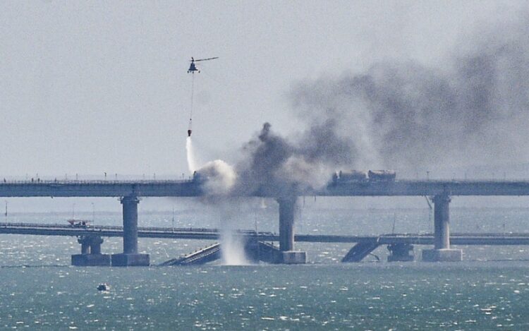 Ελικόπτερο ρίχνει νερό στο κατεστραμμένο τμήμα της γέφυρας της Κριμαίας, τον Οκτώβριο του 2022 (φωτ.: EPA/Stringer)
