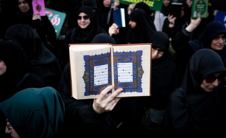 Ένας διαδηλωτής κρατά ένα αντίγραφο του Κορανίου καθώς παρευρίσκεται σε μια διαμαρτυρία κατά της Σουηδίας μπροστά από το Γενικό Προξενείο της Σουηδίας στην Κωνσταντινούπολη (φωτ.: EPA/Sedat Suna)