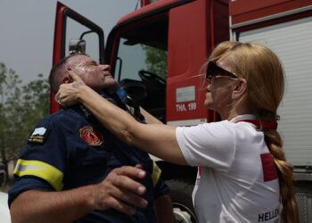Η φωτογραφία του Βασίλη Ρεμπάπη με τον πυροσβέστη να δέχεται τις πρώτες βοήθειες έγινε viral. Έχει τραβηχτεί στη Νέα Πέραμο, στην περιοχή του Κανδηλίου (πηγή: EUROKINISSI)