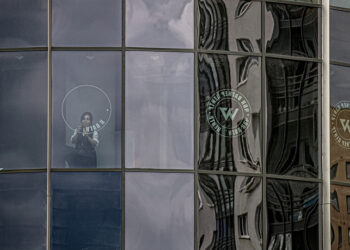 Υπάλληλος αφαιρεί το λογότυπο της Βάγκνερ από κτήριο στην Αγία Πετρούπολη (φωτ.: EPA / Anatoly Maltsev)