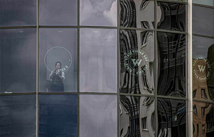 Υπάλληλος αφαιρεί το λογότυπο της Βάγκνερ από κτήριο στην Αγία Πετρούπολη (φωτ.: EPA / Anatoly Maltsev)