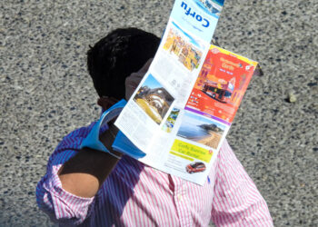Τουρίστας προστατεύει το κεφάλι του από τη ζέστη με έναν χάρτη της Κέρκυρας (φωτ.: EUROKINISSI / Γιώργος Κονταρίνης)