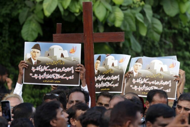 Μέλη της χριστιανικής κοινότητας κρατούν πλακάτ και πανό με την εικόνα του ιδρυτή του Πακιστάν Muhammad Ali Jinnah που είχε μιλήσει για ανεξιθρησκεία (φωτ.: 
EPA/RAHAT DAR)