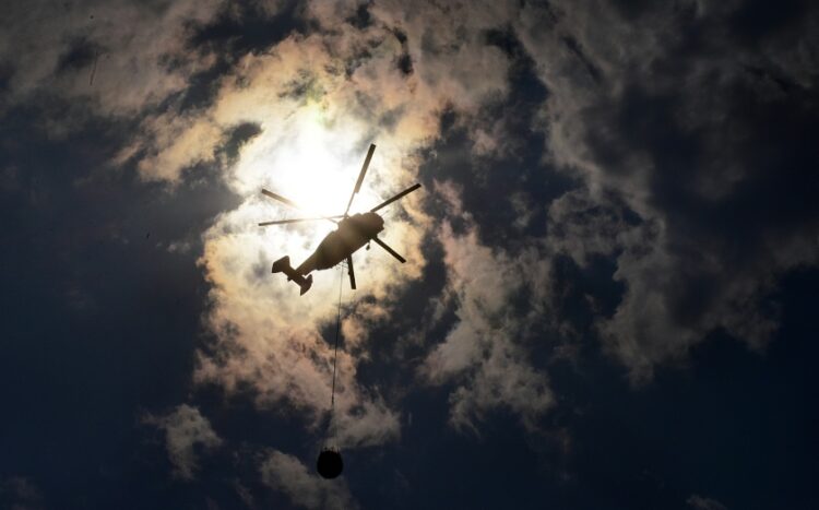 Πυροσβεστικό ελικόπτερο πραγματοποιεί ρίψεις νερού ανάμεσα στους καπνούς (φωτ.: EUROKINISSI/Βασίλης Παπαδόπουλος)