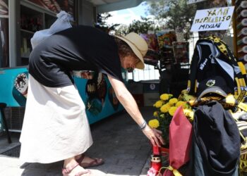 Μια γυναίκα αφήνει αναμνηστικά στον τόπο της δολοφονίας του Μιχάλη Κατσουρή (φωτ.: EUROKINISSI/Στέλιος Στεφάνου)