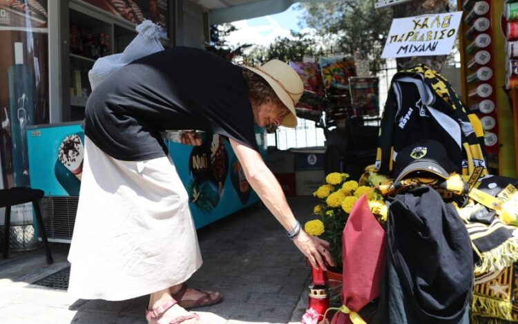 Μια γυναίκα αφήνει αναμνηστικά στον τόπο της δολοφονίας του Μιχάλη Κατσουρή (φωτ.: EUROKINISSI/Στέλιος Στεφάνου)