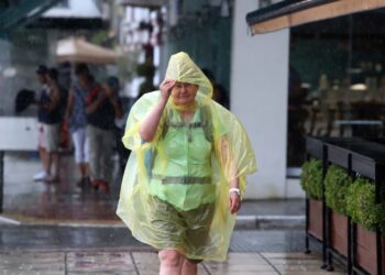 Τουρίστρια στη Θεσσαλονίκη προσπαθεί να προφυλαχθεί από την ξαφνική βροχή (φωτ.: ΜΟΤΙΟΝΤΕΑΜ/Φανή Τρυψάνη)