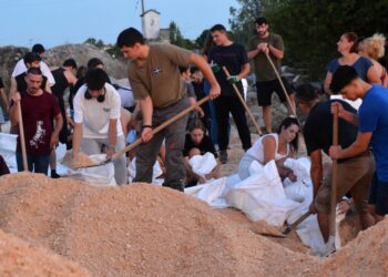 Πλήθος εθελοντών Λαρισαίων, στην πλειοψηφία τους νεαρά παιδιά, γεμίζουν και μεταφέρουν τσουβάλια με άμμο, βοηθώντας τους εργαζόμενους στο δημοτικό φυτώριο Λάρισας, για την ενίσχυση των αναχωμάτων του Πηνειού ποταμού, (φωτ.: ΑΠΕ-ΜΠΕ/Αποστόλης Ντομαλης)