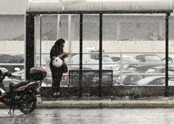 Οδηγός δικύκλου έχει σταματήσει σε στάση για να προφυλαχθεί από τη βροχή (φωτ. αρχείου: Eurokinissi/Μιχάλης Καραγιάννης)