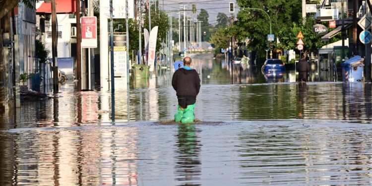Κάτοικος διασχίζει με σακούλες στα πόδια πλημμυρισμένο δρόμο της Λάρισας, Σάββατο 9 Σεπτεμβρίου 2023 (φωτ.:Eurokinissi/Μιχάλης Καραγιάννης)