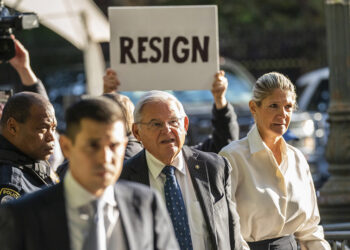 «Παραιτήσου» γράφει το πλακάτ, την ώρα που ο Μπομπ Μενέντεζ εισέρχεται στο ομοσπονδιακό δικαστήριο του Μανχάταν (φωτ.: EPA / Eduardo Munoz)