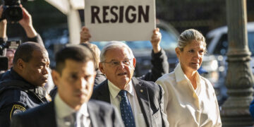 «Παραιτήσου» γράφει το πλακάτ, την ώρα που ο Μπομπ Μενέντεζ εισέρχεται στο ομοσπονδιακό δικαστήριο του Μανχάταν (φωτ.: EPA / Eduardo Munoz)