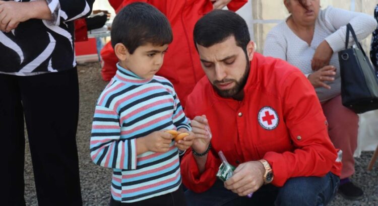 Μικρός πρόσφυγας δέχεται τη φροντίδα διασώστη του Ερυθρού Σταυρού στα εδάφη της Αρμενίας (φωτ.: CivilNet/Levon Hakobyan)