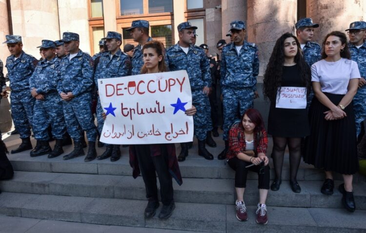 Αστυνομικοί στο Γερεβάν φρουρούν κυβερνητικό κτήριο στη διάρκεια διαμαρτυρίας χθες, Τρίτη, μετά την επίθεση των αζερικών δυνάμεων στο Αρτσάχ. Το πανό, σε ελεύθερη μετάφραση, αναγράφει «Τερματίστε την κατοχή» (φωτ.: EPA/Narek Aleksanyan)