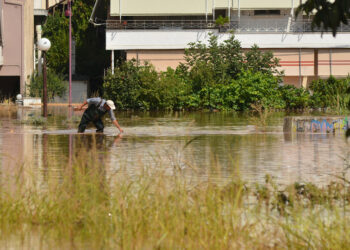 Άνδρας περπατάει σε πλημμυρισμένο δρόμο στη συνοικία του Ιπποκράτη στην Λάρισα, κατά τη διάρκεια της κακοκαιρίας Daniel (φωτ.: ΑΠΕ-ΜΠΕ / Αποστόλης Ντόμαλης)
