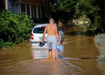 Νεαρός σε πλημμυρισμένη περιοχή της Λάρισας μεταφέρει μια εξάδα με νερά (φωτ.: EUROKINISSI/Λεωνίδας Τζέκας)