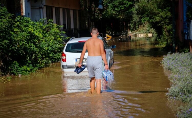 Νεαρός σε πλημμυρισμένη περιοχή της Λάρισας μεταφέρει μια εξάδα με νερά (φωτ.: EUROKINISSI/Λεωνίδας Τζέκας)