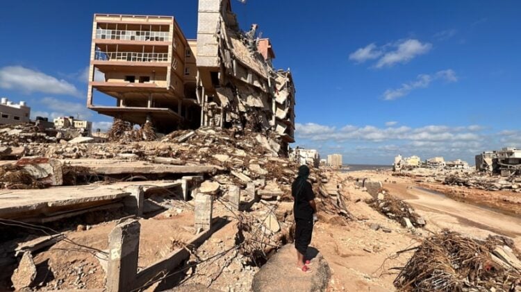 Λίβυος στέκεται κοντά σε κατεστραμμένα κτήρια στην πόλη Ντέρνα, η οποία καταστράφηκε σε μεγάλο μέρος από την κακοκαιρία «Daniel» (φωτ.: . EPA/Stringer)