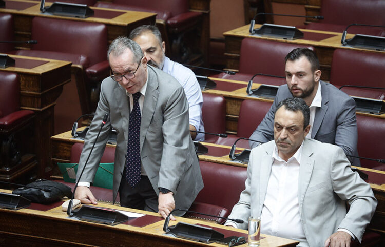 Ο Κωνσταντίνος Φλώρος (πίσω, δεξιά) στα κοινοβουλευτικά έδρανα, με τον Βασίλη Στίγκα μπροστά του (φωτ.: EUROKINISSI / Βασίλης Ρεμπάπης)