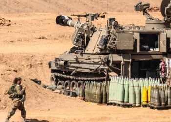 Ισραηλινή στρατιωτικός μπροστά από τεθωρακισμένο του Ισραήλ το οποίο είναι σε θέση μάχης στα σύνορα με τη Γάζα (φωτ.: EPA/Hannibal Hanschke)