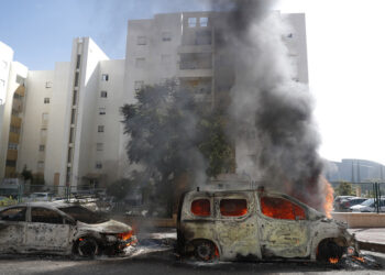 Φλεγόμενα οχήματα στην ισραηλινή πόλη Ασκελόν, η οποία χτυπήθηκε από πυραύλους που εκτοξεύτηκαν από τη Λωρίδα της Γάζας (φωτ.: EPA / Atef Safadi)
