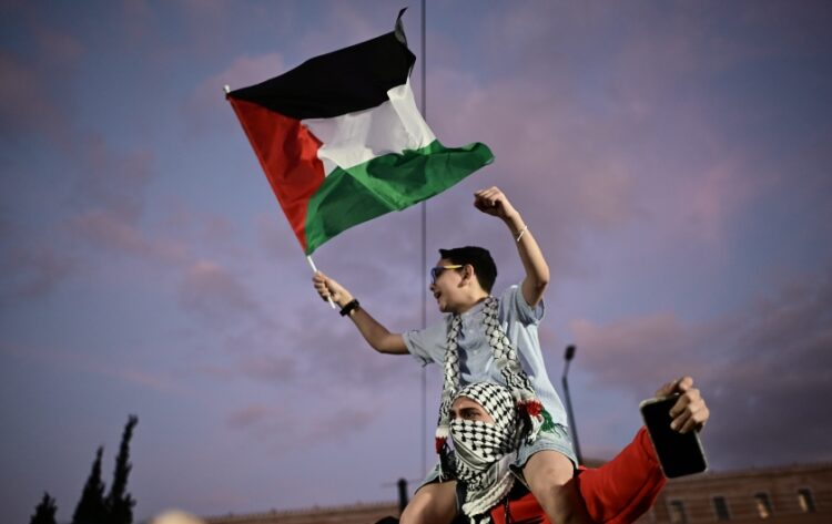 Νεαρός διαδηλωτής κρατά σημαία της Παλαιστίνης στη διάρκεια της διαδήλωσης στο κέντρο της Αθήνας (φωτ: EUROKINISSI/Μιχάλης Καραγιάννης)