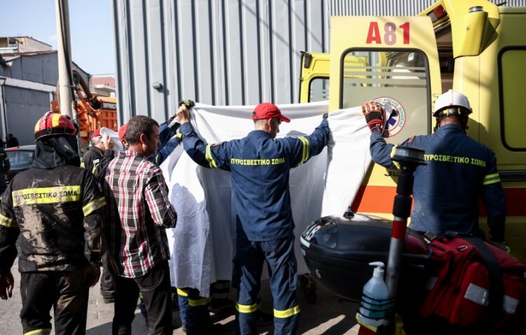 Μέλη του Πυροσβεστικού Σώματος μεταφέρουν τη σορό του άτυχου άνδρα στο ασθενοφόρο (φωτ.: EUROKINISSI/Βασίλης Ρεμπάπης)