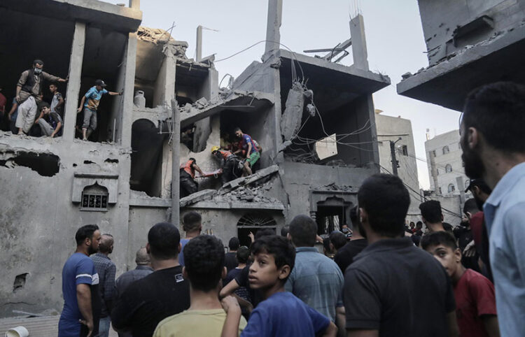 Παλαιστίνιοι αναζητούν επιζώντες και σορούς σε κατεστραμμένο από τους αεροπορικούς βομβαρδισμούς κτήριο στην πόλη Χαν Γιουνίς (φωτ.: EPA / Haitham Imad)