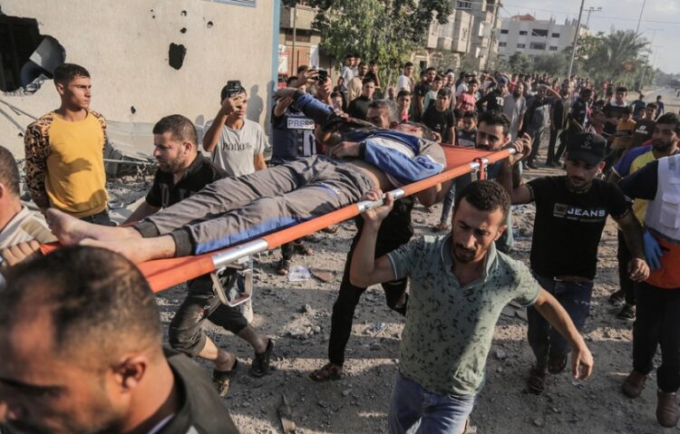 Παλαιστίνιοι μεταφέρουν τραυματία μετά από το χτύπημα ισραηλινής ρουκέτας σε καταυλισμό στη νότια Γάζα (φωτ.: EPA/Haitham Imad)