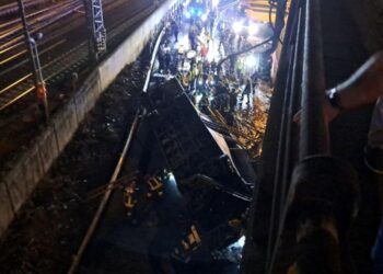 Σωστικά συνεργεία επιχειρούν στο σημείο της τραγωδίας, όπου το λεωφορείο έπεσε στο κενό και προσγειώθηκε πάνω σε σιδηροδρομικές γραμμές (φωτ.: EPA/Andrea Buoso)