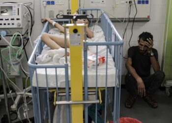 Παλαιστίνιος κάθεται δίπλα στο τραυματισμένο παιδί του, το οποίο νοσηλεύεται στη ΜΕΘ νοσοκομείου της Γάζας (φωτ.: EPA/Haitham Imad)