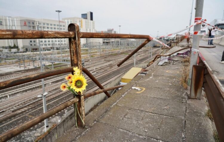 Λίγα λουλούδια στο σημείο όπου έπεσε το λεωφορείο παρασύροντας στο θάνατο 21 ανθρώπους. Διακρίνεται το κιγκλίδωμα, το οποίο φαίνεται παλιό και σκουριασμένο (φωτ.: EPA/Marco Albertini)