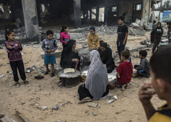 Εκτοπισμένοι Παλαιστίνιοι μπροστά από τα ερείπια βομβαρδισμένου κτηρίου (φωτ.: EPA / Haitham Imad)