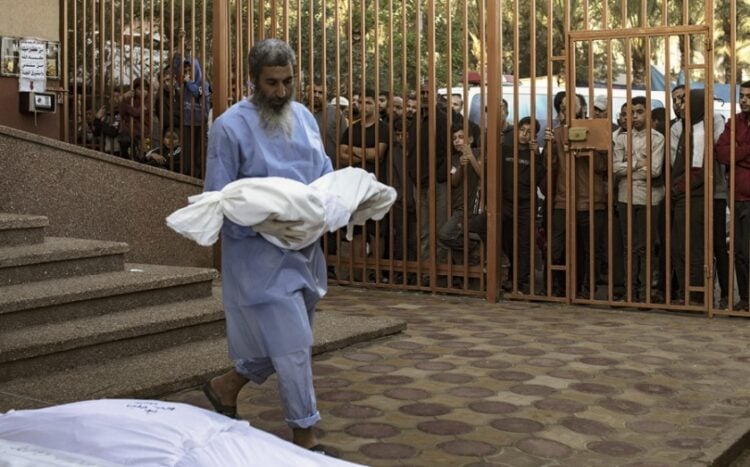 Νοσηλευτής στην αυλή του νοσοκομείου Νασέρ στη Χαν Γιουνίς, κρατά τη σορό ενός παιδιού, θύμα του πλήγματος στον καταυλισμό της Τζαμπαλίγια (φωτ.: EPA/Haitham Imad)