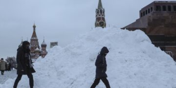 Πολίτες περνούν δίπλα από σωρούς χιονιού στην Κόκκινη Πλατεία της Μόσχας τον Δεκέμβριο του 2022 (φωτ.: EPA/Maxim Shipenkov)