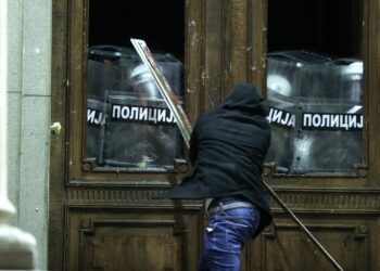 Διαδηλωτής που διαμαρτύρεται για αλλοίωση του εκλογικού αποτελέσματος προσπαθεί να μπει με τη βία στο κτήριο του δημαρχείου στο Βελιγράδι (φωτ.: EPA/Andrej Cukic)