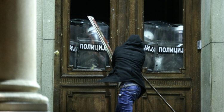 Διαδηλωτής που διαμαρτύρεται για αλλοίωση του εκλογικού αποτελέσματος προσπαθεί να μπει με τη βία στο κτήριο του δημαρχείου στο Βελιγράδι (φωτ.: EPA/Andrej Cukic)