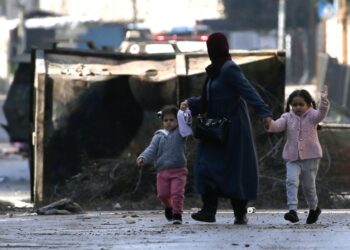 Παλαιστίνια μητέρα με τα παιδιά της εγκαταλείπει το στρατόπεδο προσφύγων της Τζενίν για να βρει ασφαλέστερο μέρος μετά το χτύπημα των ισραηλινών (φωτ.: EPA/Alaa Badarneh)