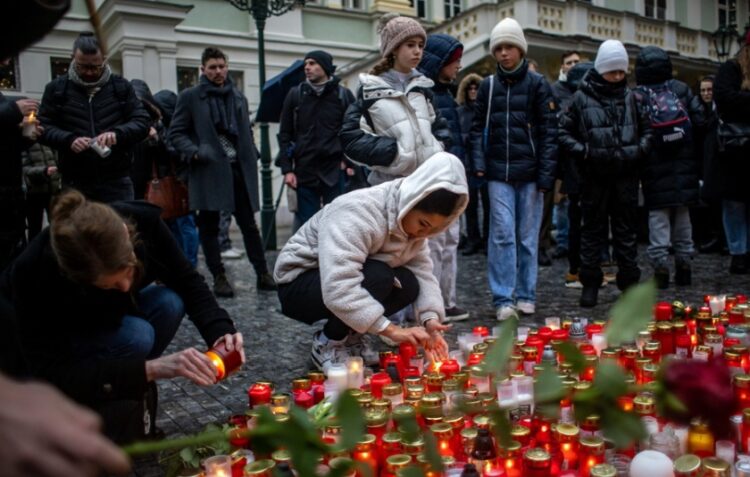 Πολίτες αφήνουν αναμμένα κεριά έξω από το Πανεπιστήμιο του Καρόλου, όπου ο 24χρονος πυροβόλησε και σκότωσε στα τυφλά 13 άτομα (φωτ.: EPA/Martin Divisek)
