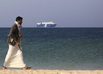 Ένοπλος αντάρτης των Χούθι σε ακτή της Υεμένης με φόντο εμπορικό πλοίο (φωτ.: EPA / Yahya Arhab)