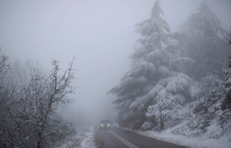 Aυτοκίνητο διασχίζει χιονισμένο δασικό δρόμο στο βουνό του Χορτιάτη (φωτ.: ΑΠΕ-ΜΠΕ / Δημήτρης Τοσίδης)