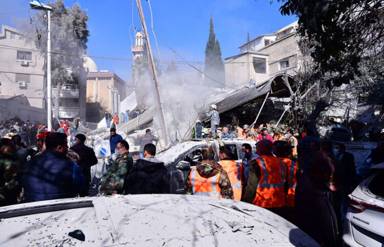 Διασώστες και στρατιώτες κοντά στα συντρίμμια του κτηρίου που χτυπήθηκε, στη συνοικία Μαζέ στη Δαμασκό (φωτ.: EPA/STR)