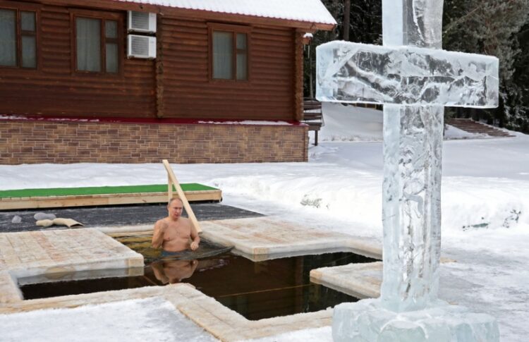 Ο Ρώσος πρόεδρος κάνει το σταυρό του εν μέσω των παγωμένων υδάτων στη Μόσχα (φωτ.: EPA/Mikhael Klimentyev)